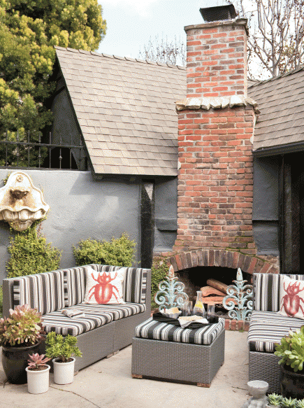 Cozy Corner Outdoor Fireplace Design with Modern Touches, Bug Pillows, Gray Furniture 