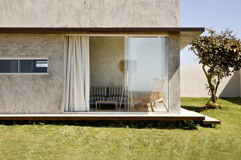 Concrete Wall and Wide Glass Walls near Green Grass Yard