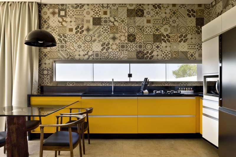 Kitchen with Yellow Cabinets and Yellow Drawers near Glass Table and Wooden Chairs