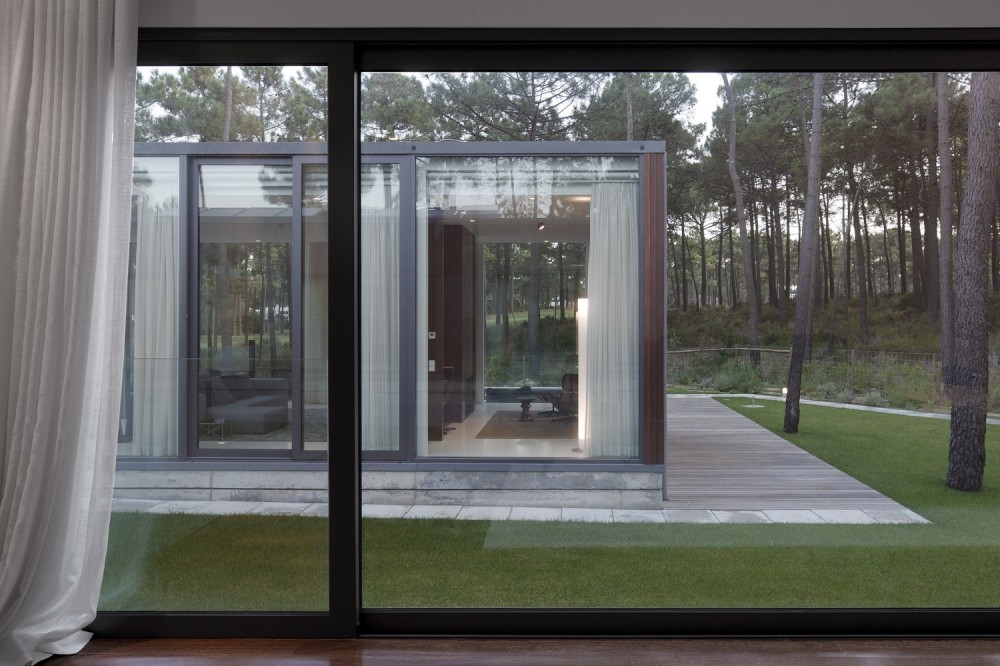 Design from Aroeira III House Among Floor To Ceiling Window Showing Transparency Also Trees Covered By White Curtain Design from Aroeira III House Among Floor To Ceiling Window Showing Transparency Also Trees Covered By White Curtain