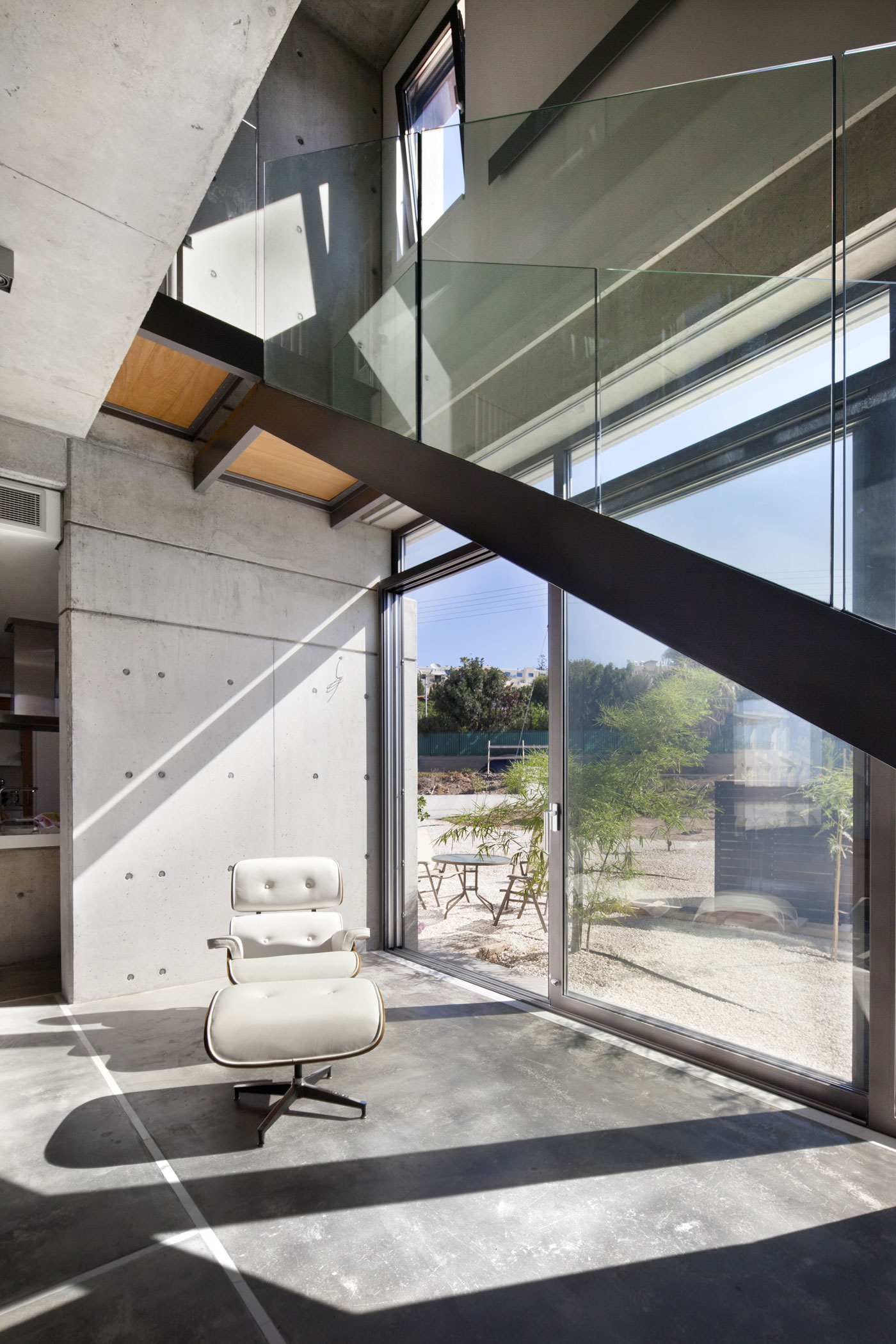 Andri & Yiorgos Residence - White Chair Grey Concrete Floor Also Windows Which Are Made From Glass Panels Andri & Yiorgos Residence - White Chair Grey Concrete Floor Also Windows Which Are Made From Glass Panels