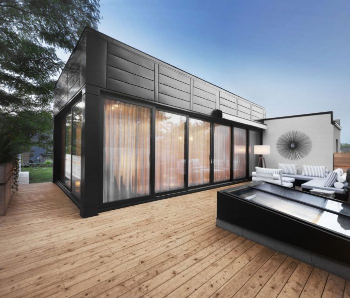 Interesting Black Tiled Wall Installed On Wooden Stripes Floor Near Wooden Glass Windows Inside Clear Canvas On A Green Roof House