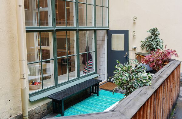 Balcony Decoration Including Potted Plants Combined Near Black Wooden Bench Near Bay Windows On Wall
