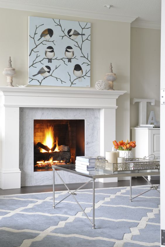 Fireplace decorated with a Carrera marble surround and white mantle