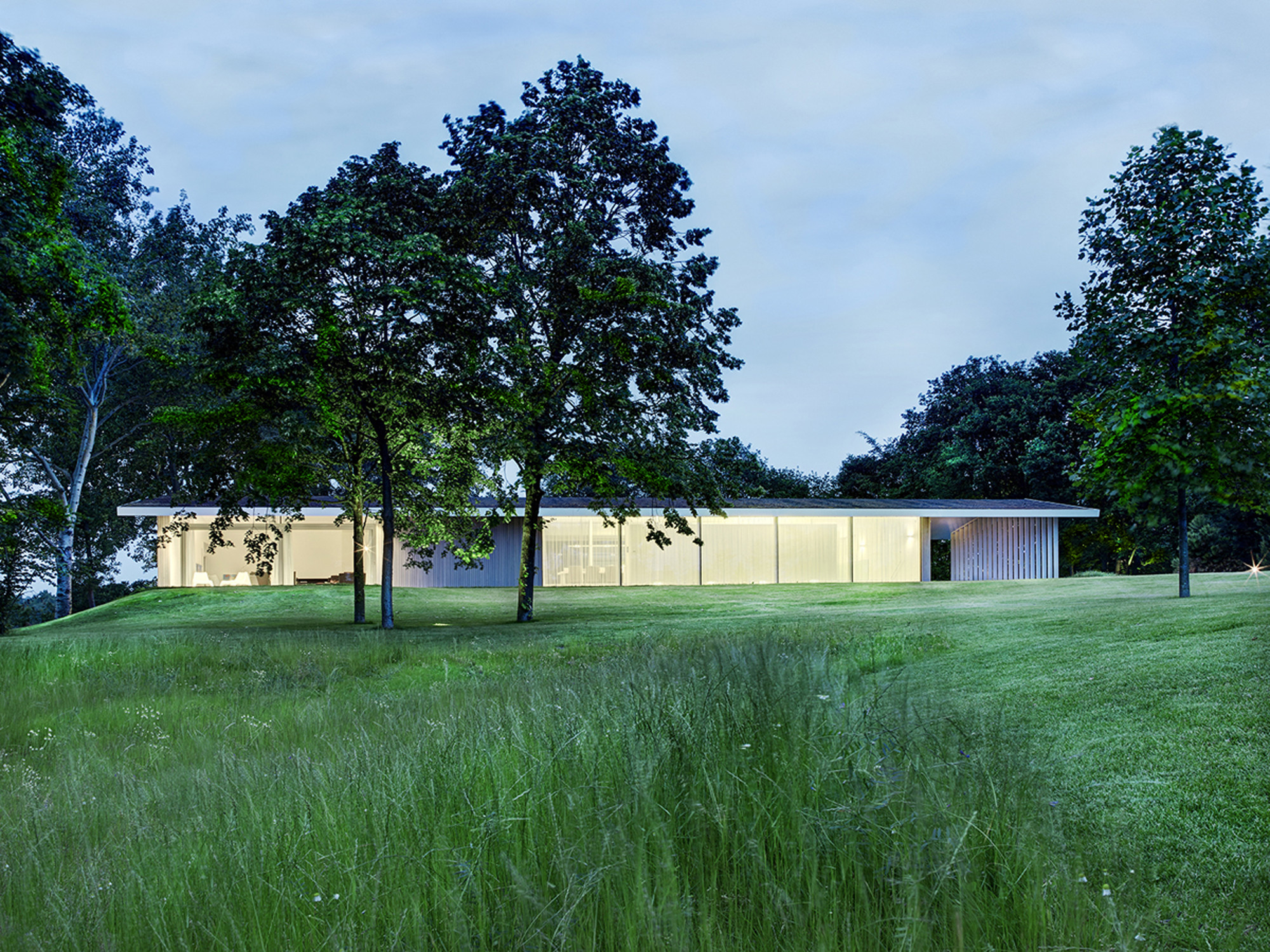 House Near Clear Colored Outer Wall Along With Bright Yellow Lighting Inside House Near Clear Colored Outer Wall Along With Bright Yellow Lighting Inside