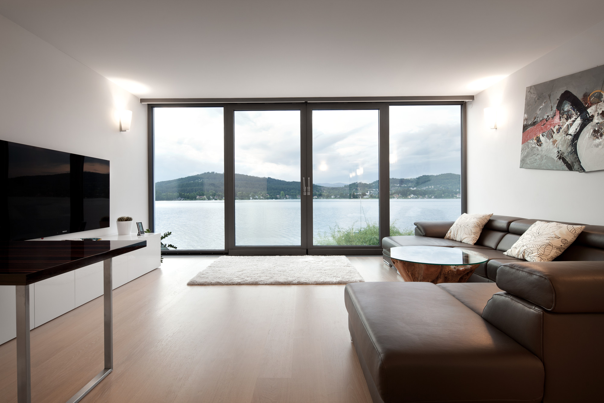 Living Room with Lake View Applied Timber Floor Along With Large Glass Window Living Room with Lake View Applied Timber Floor Along With Large Glass Window
