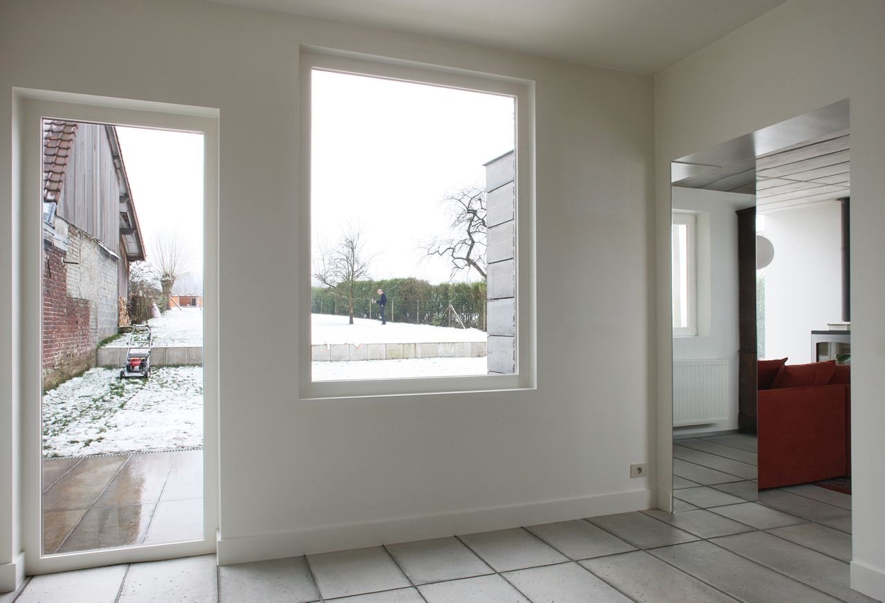 House H by Architecten de Vylder Vinck Taillieu - Greenery Seen From Home Hallway Near Red Couch Inside Living Room House H by Architecten de Vylder Vinck Taillieu - Greenery Seen From Home Hallway Near Red Couch Inside Living Room