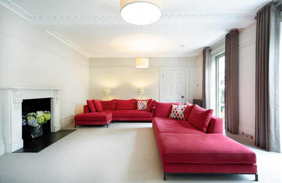 White living room with red sofa